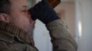 Ein obdachloser Mann trinkt aus einer Flasche Bier.