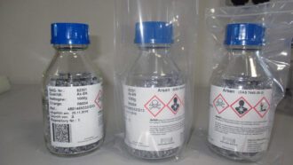 Fläschchen mit Arsengranulat. Darauf die Warnzeichen „Giftig“, „Gesundheitsschädlich“ und „Umweltgefährlich“.