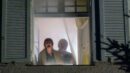 Ein älteres Ehepaar steht am Fenster und ruft aus einem verrauchten Zimmer heraus um Hilfe.