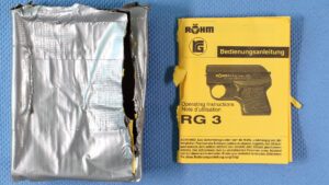 Die Verpackung und Bedienungsanleitung einer Schreckschusswaffe Röhm RG3. Die Verpackung wurde mit Klebeband umwickelt.