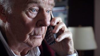 Ein älterer Herr ist am Telefon. Sein Blick ist fassungslos.