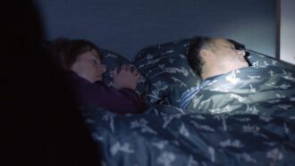 Ein schlafendes Ehepaar wird von einer Taschenlampe angeleuchtet, als die Täter in das Haus eindringen.