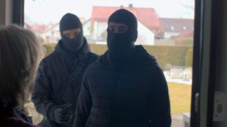 Als eine Frau die Tür öffnet, steht sie zwei maskierten Männern gegenüber