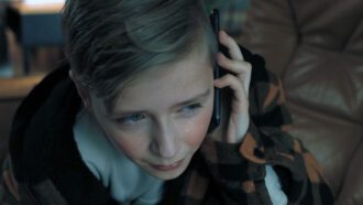 Ein kleiner Junge hält sich weinend ein Smartphone an sein Ohr.