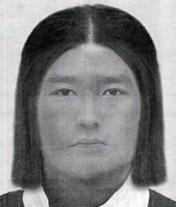 Ein asiatisch anmutender Mann mit Mittelscheitel und kinnlagen, glatten Haaren.