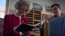Eine betagte Frau schreibt in ein Notizbuch.