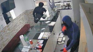 Zwei Männer verlassen nach dem Raub hastig das Juweliergeschäft.