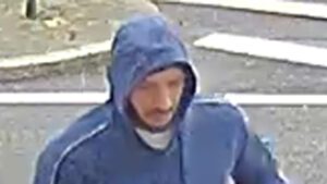 Ein unmaskierter Mann in blauer Trainingsjacke.