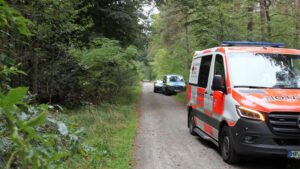 Einsatzkräfte auf dem Weg zum Tatort im Stadtwald in Lampertheim.